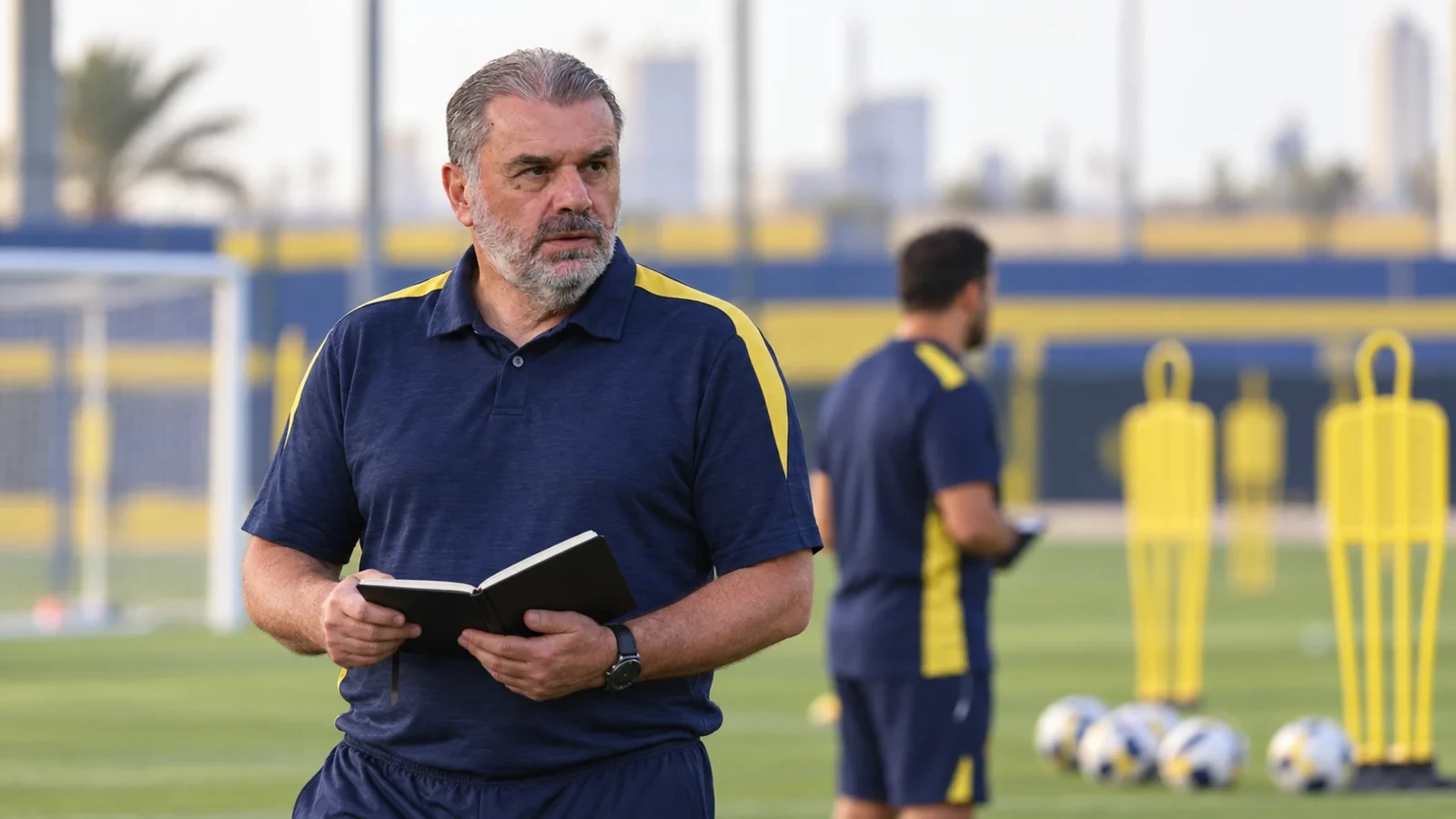 Minh họa Ange Postecoglou xem sổ ghi chú trước buổi tập của Al Nassr